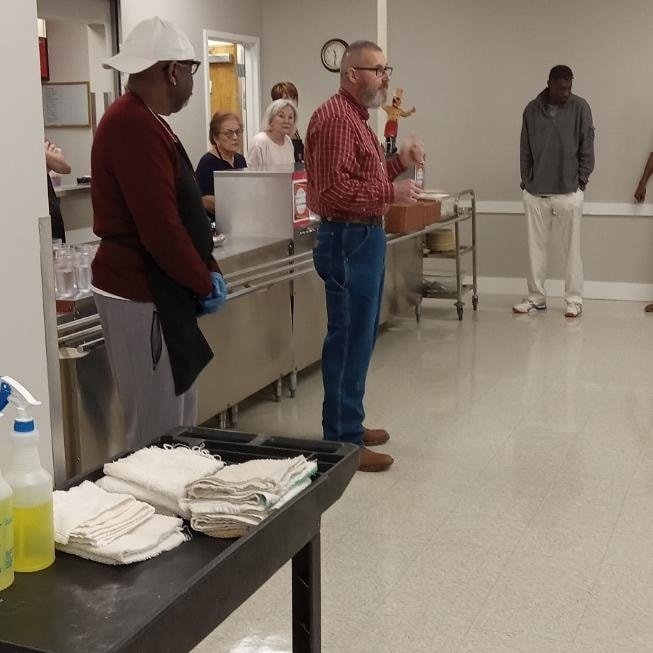 Community members gathered in a meal-service space